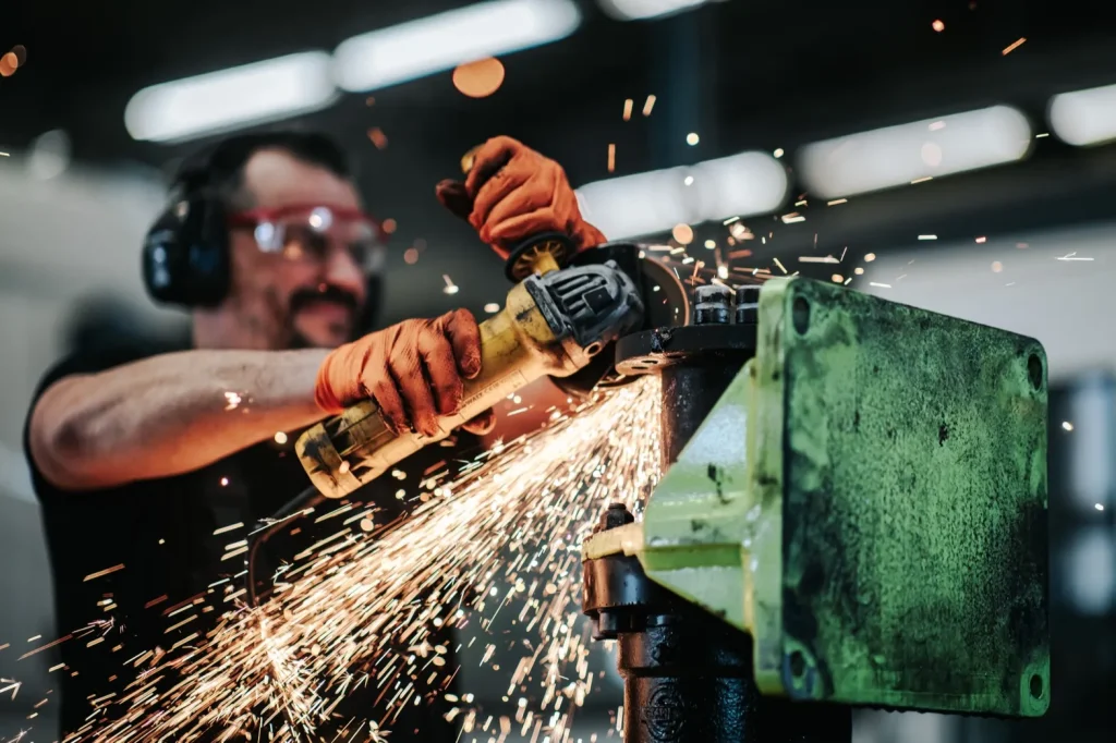 Collaborateur utilisant une meuleuse avec étincelles